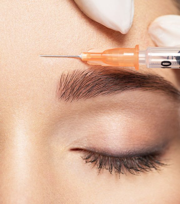 Woman receiving a BOTOX® Cosmetic injection in her forehead