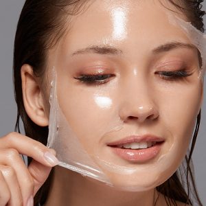 Woman peeling a mask off of her face