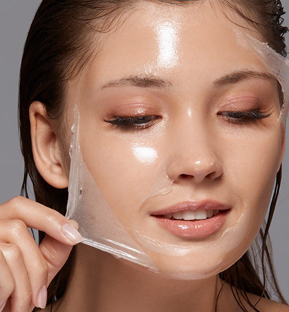 Woman peeling a mask off of her face