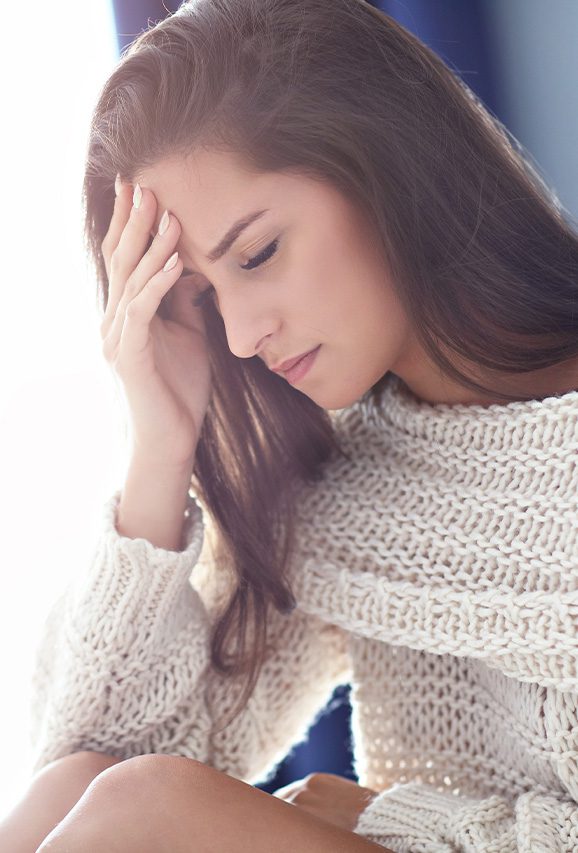 Woman holding her forehead