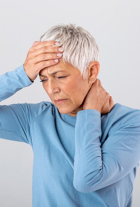 Older woman with hand on the back of her neck and forehead