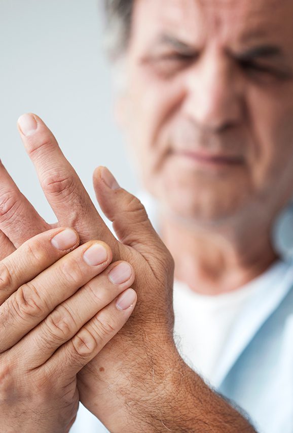 Older man holding his hand