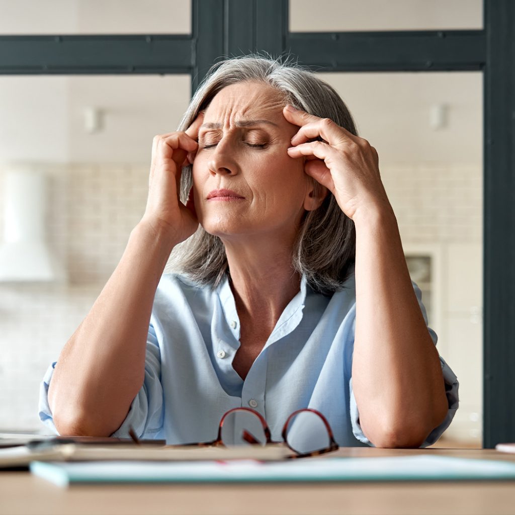 Middle aged woman with hands on her temples