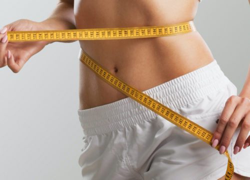 Woman with measuring tape around her waist.