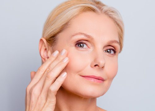 Woman touching her cheek after a Sculptra treatment