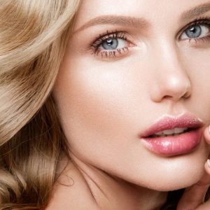 Woman with lip filler on a grey background